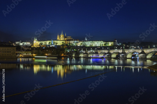 Prague Castle and Charles Bridge at night, blue sky and river, Czech republic