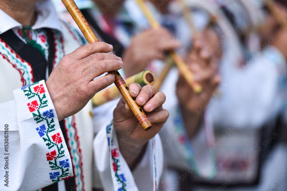 People singing at traditional wooden flutes People singing at traditional wooden flutes