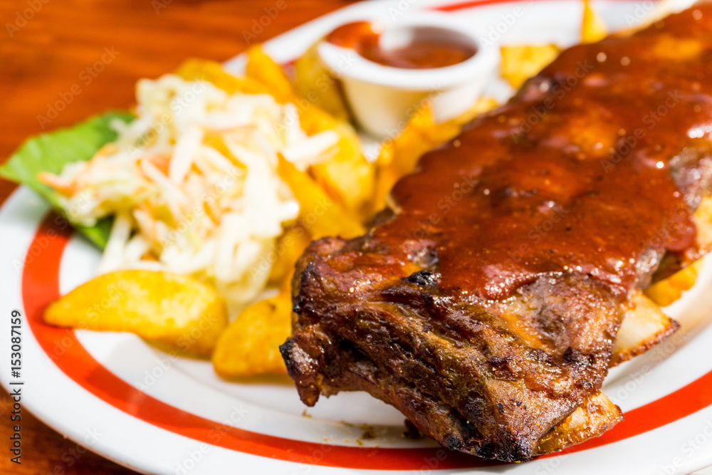 Grilled steak - Grilled meat ribs on the plate with hot sauce Grilled steak - Grilled meat ribs on the plate with hot sauce