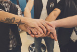Men friendship. United hands of young team with tattoo.
