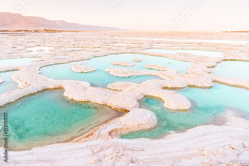 View of Dead Sea coastline. Salt crystals at sunset. Texture of Dead sea. Salty sea shore photo