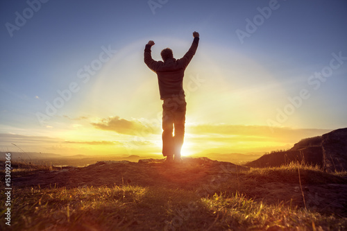 Happy man celebrating winning success against sunset