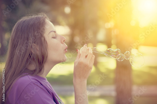 Young woman blows bubbles