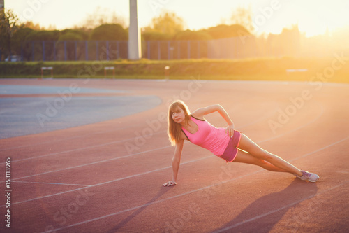 sport and lifestyle concept - woman doing warm up on sunset