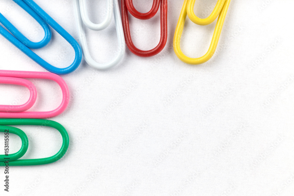 Colored clips on white paper, with nice paper texture