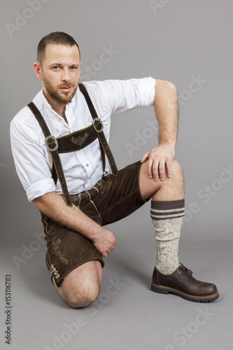 Fényképezés man in bavarian traditional lederhosen kneeling