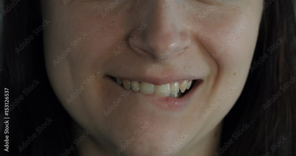 Close up of young woman licking lips and smiling. Close up. Brown hair