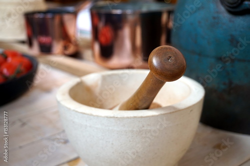Shallow focus image of a vintage mortar and pestle in a rustic table setting