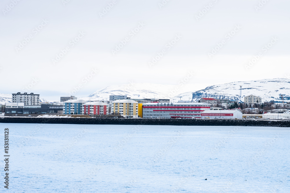 Colorful Building foreground and snow-capped mountain in the background. Beautiful view of Iceland winter season.