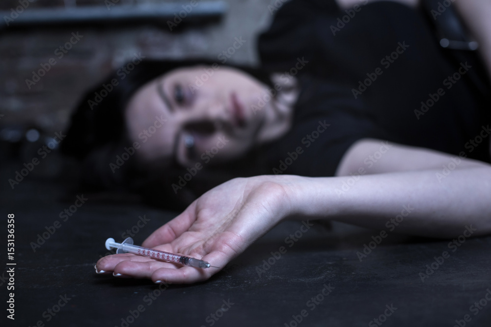 Exhausted drug addict lying on the ground