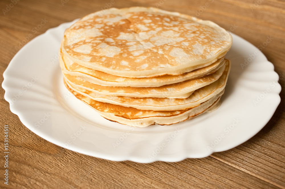 Pancake on the plate.  Wooden background.