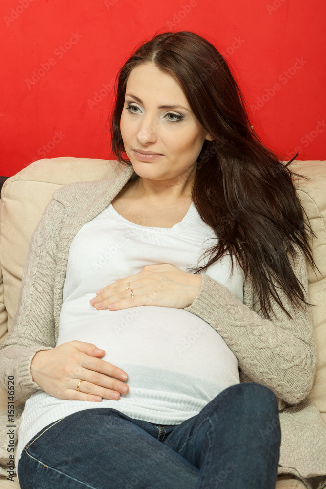 Fototapeta premium Pregnant woman sitting and relaxing on sofa