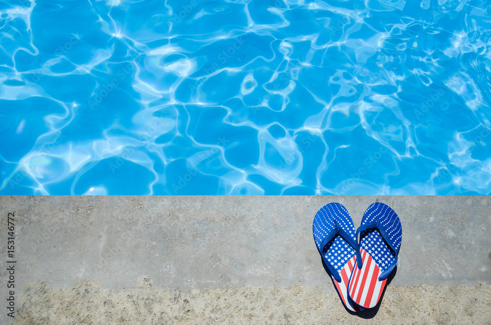 Naklejka premium Summer background with flip flops near the pool