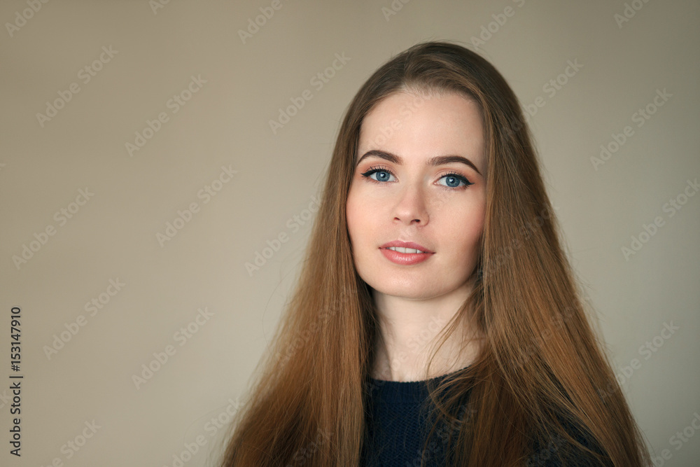 Indoor headshot of happy natural looking beautiful woman in dark blue sweater beige background. Indoor headshot of happy natural looking beautiful woman in dark blue sweater beige background.