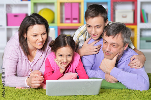 Happy family with children behind laptop