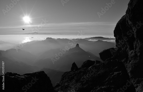 Silhouettes of mountains at sunset, summit of Gran canaria, Roque Bentayga and Tenerife island in the distance, Canary islands, monochrome mode photo