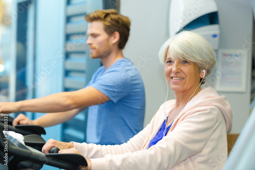 elderly lady and young man using treadmill © auremar