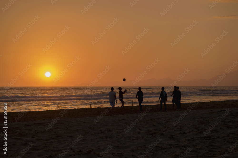 silhouette of boy how plays football in the sunset