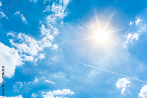 Sunny background, blue sky with white clouds and sun photo