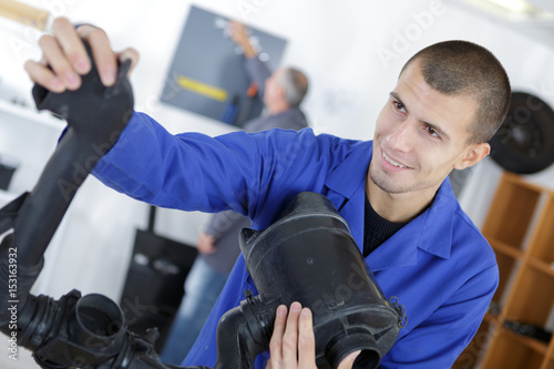 Smiling engineer with black plastic pipework