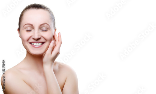 Portrait of a smiling girl with nude make-up with hands on chin isolated on white background. Girl with clean healthy skin on white. Copy space. Beauty model isolated on white. Smile, white teeth.