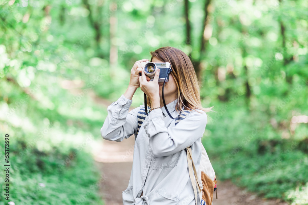 Young woman taking a photograph in the nature