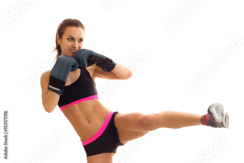 young Super athletic girl in boxing gloves and lifted her top leg up © ponomarencko
