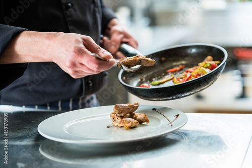 Принти на полотні Chef finishing food on plate in restaurant kitchen