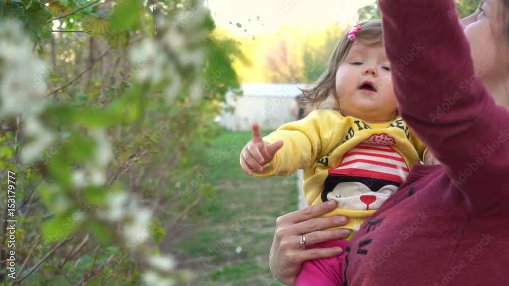 Mother show to baby flowers on trees in slowmo Mother show to baby flowers on trees in slowmo