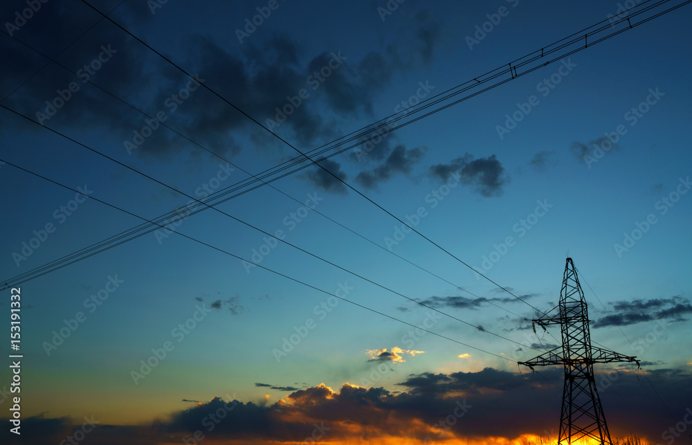 Power lines against the sky at sunset