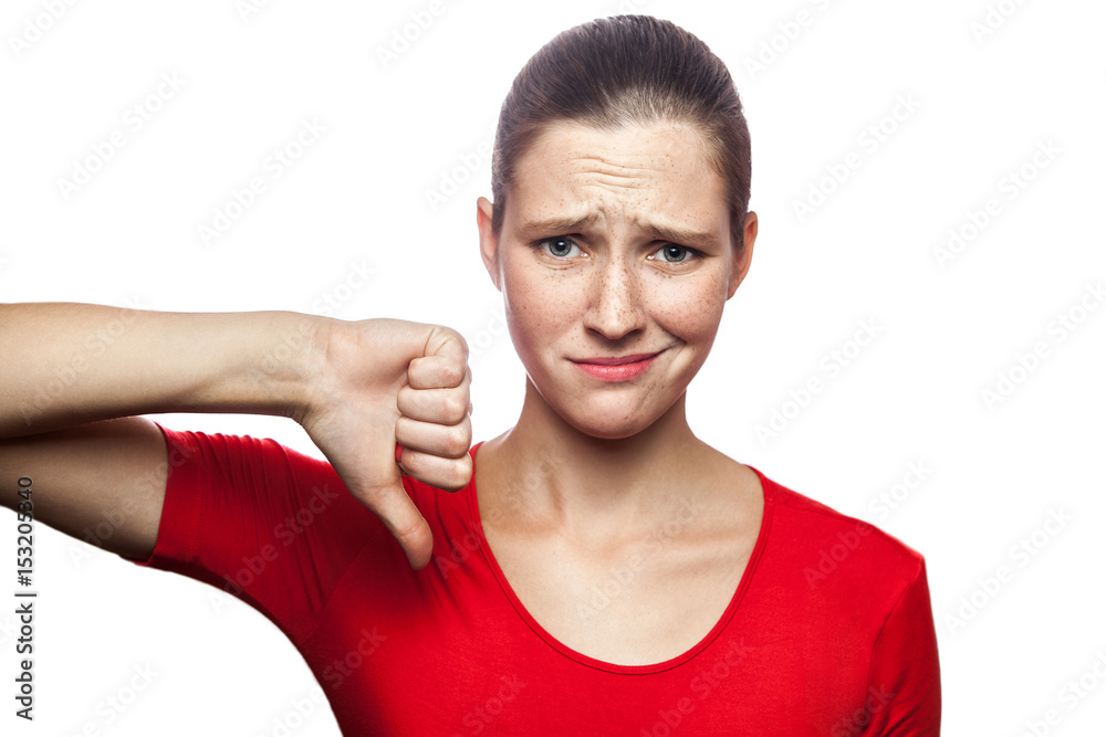 Φωτογραφία Portrait of unhappy sad woman in red t-shirt with freckles with finger down