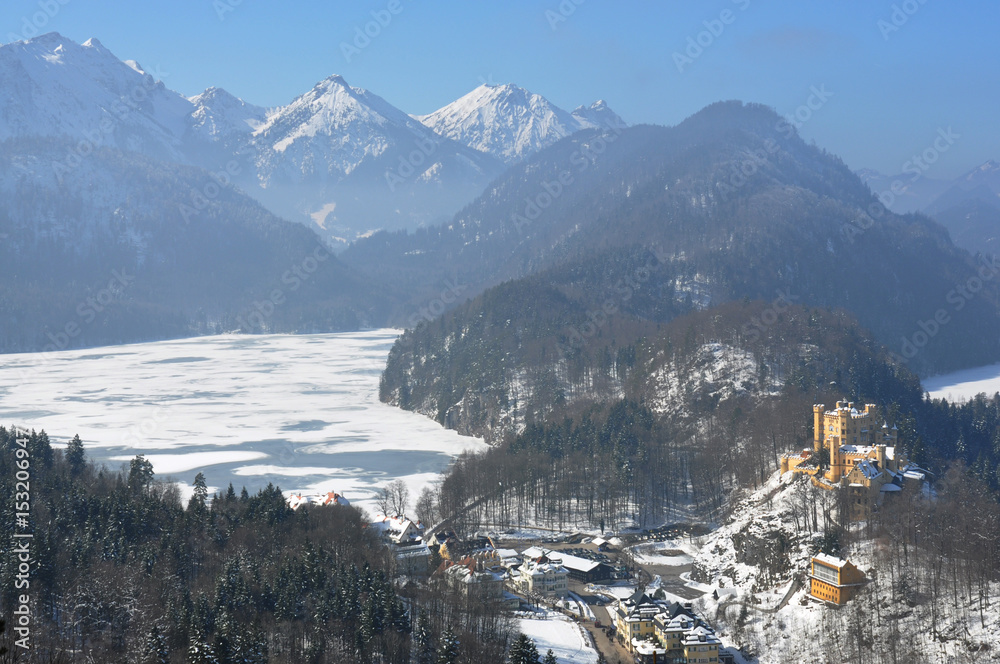 Hohenschwangau castle, village and Alpsee lake with the mountain range in the background, aerial view