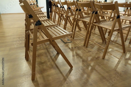 lines of wooden chairs prepared for audience