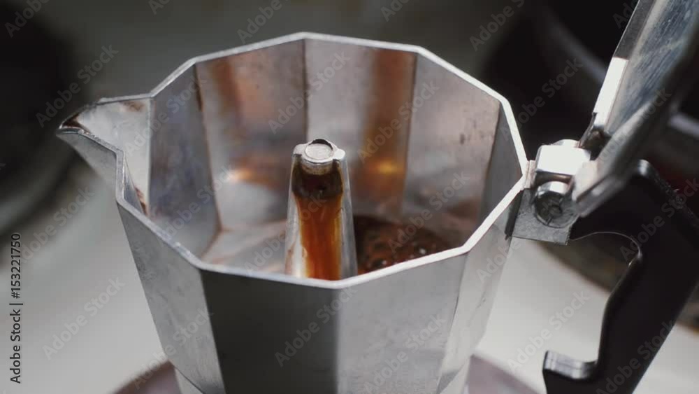 Moka pot brewing on a stove. Italian espresso coffee boiling in a moka pot close-up
