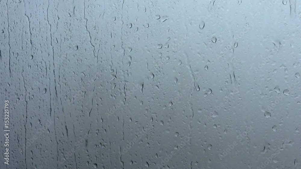 Background shot of rainy water drips on a window glass