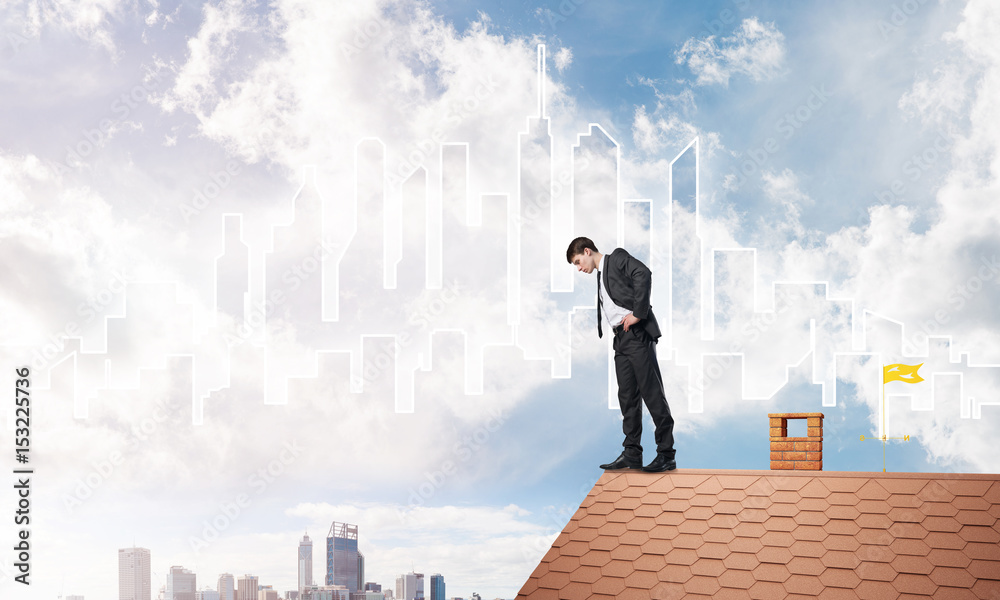 Businessman looking down from roof and modern cityscape at background. Mixed media Businessman looking down from roof and modern cityscape at background. Mixed media