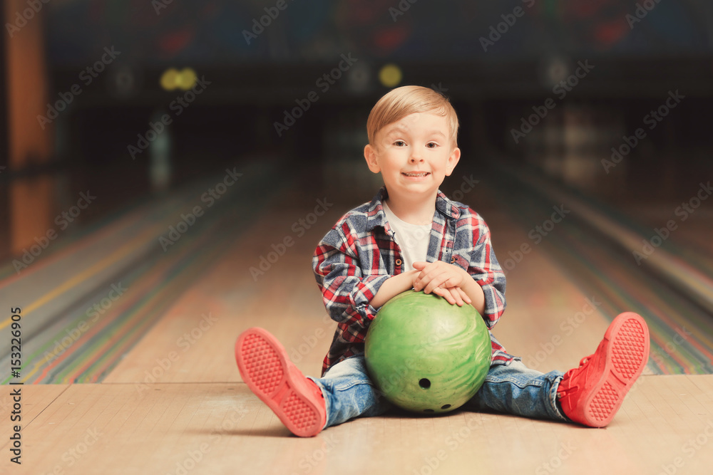 Fototapeta premium Cute child with ball in bowling club