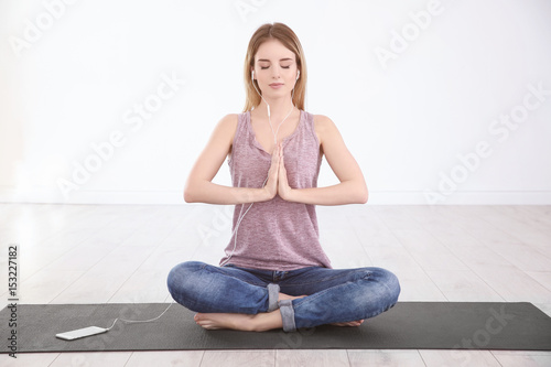 Woman doing yoga and listening to the music at home