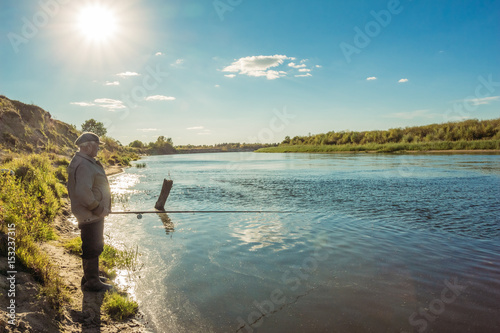 Fisherman in the river landscape at sunset