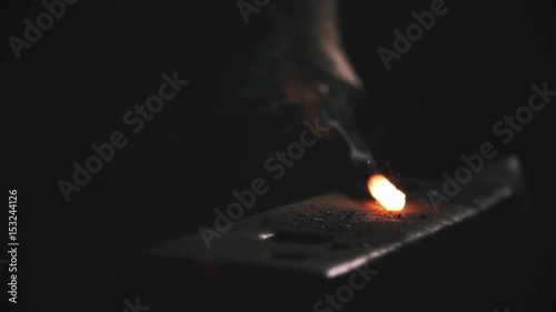 Blacksmith hitting metal at forge sparks flying 