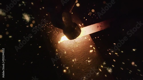 Blacksmith hitting metal at forge sparks flying 