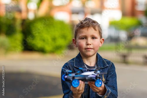 Boy plays with his drone in the park photo