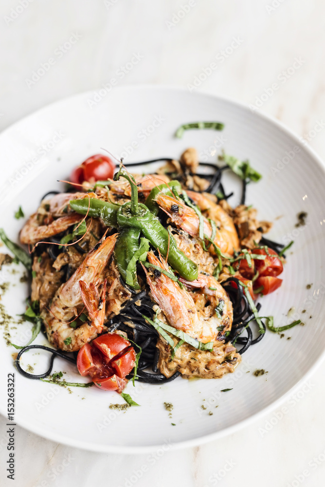 gourmet grilled prawn and vegetables on black squid ink pasta gourmet grilled prawn and vegetables on black squid ink pasta
