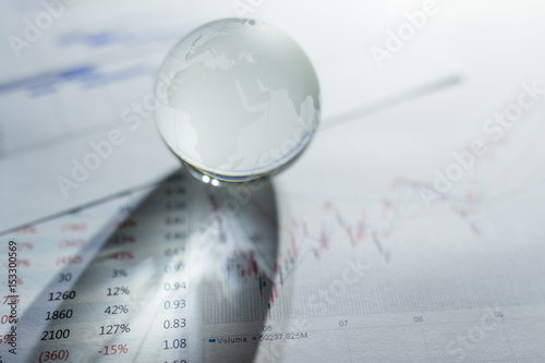 Glass globe on stock market chart