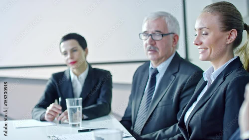 Slow motion of senior manager sitting at meeting in the office and speaking with female colleagues Slow motion of senior manager sitting at meeting in the office and speaking with female colleagues