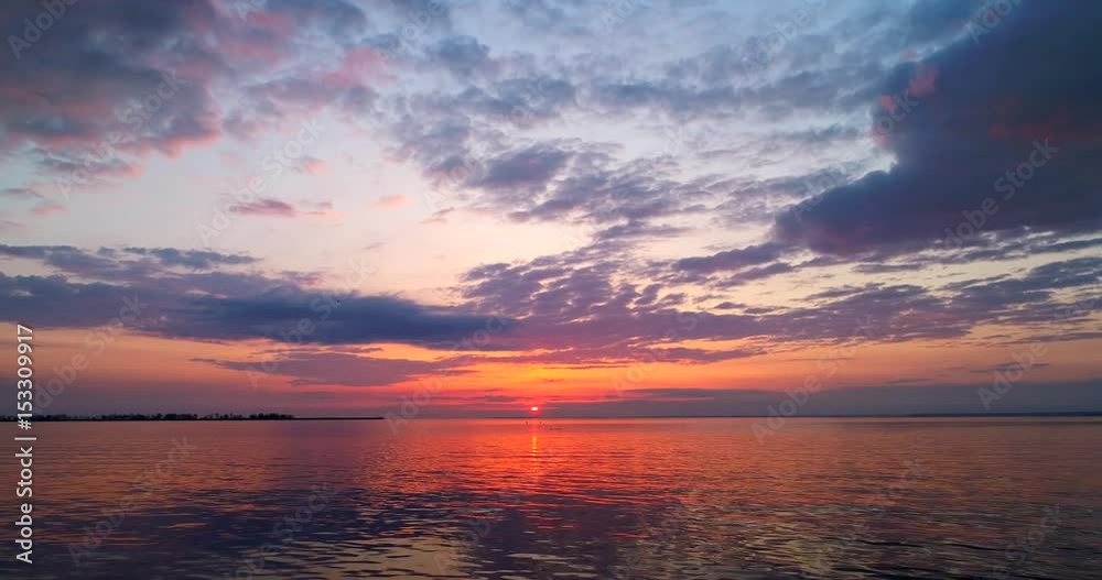 Breathtaking colorful, dramatic sunrise over Bay of Green Bay with tranquil swimming birds, low aerial perspective. Breathtaking colorful, dramatic sunrise over Bay of Green Bay with tranquil swimming birds, low aerial perspective.