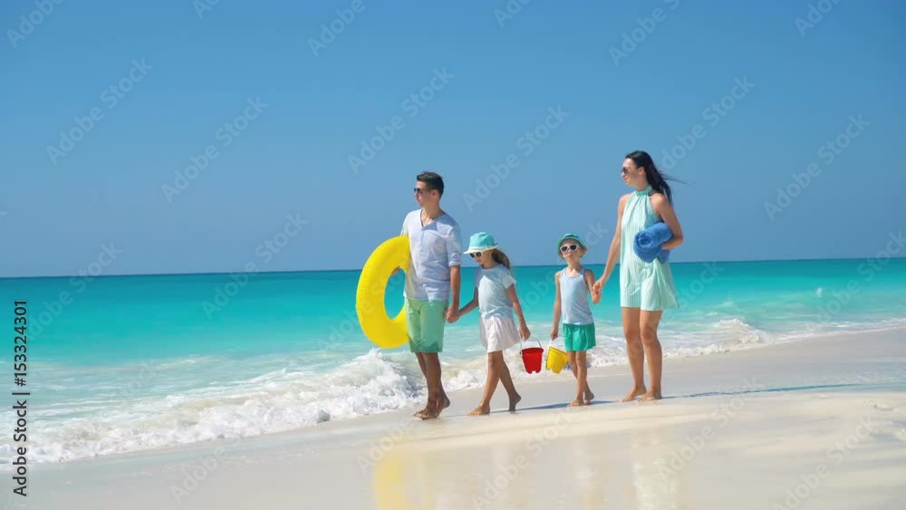 Happy beautiful family of four on a tropical beach vacation Happy beautiful family of four on a tropical beach vacation