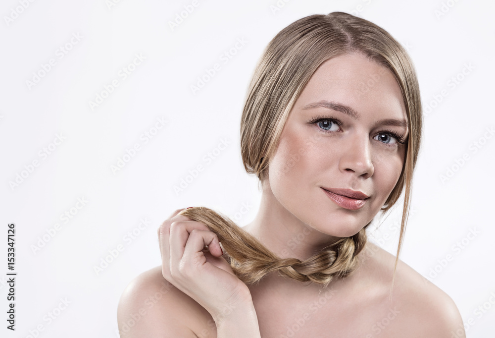 Fototapeta premium A model with blond hair braided in a braid, fair skin, bare shoulders.