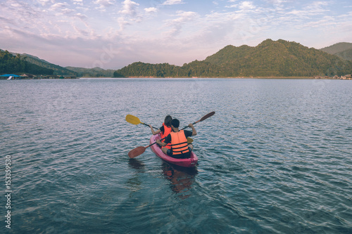 holidays, vacation, love and friendship concept - couple is kayaking in the beautiful lake at Mae Ngat dam