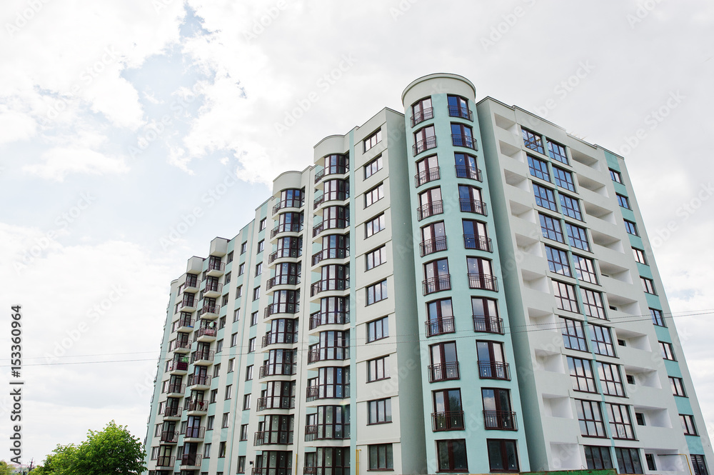 Balcony of new modern turquoise multi storey residential building house in residential area on sunny blue sky.